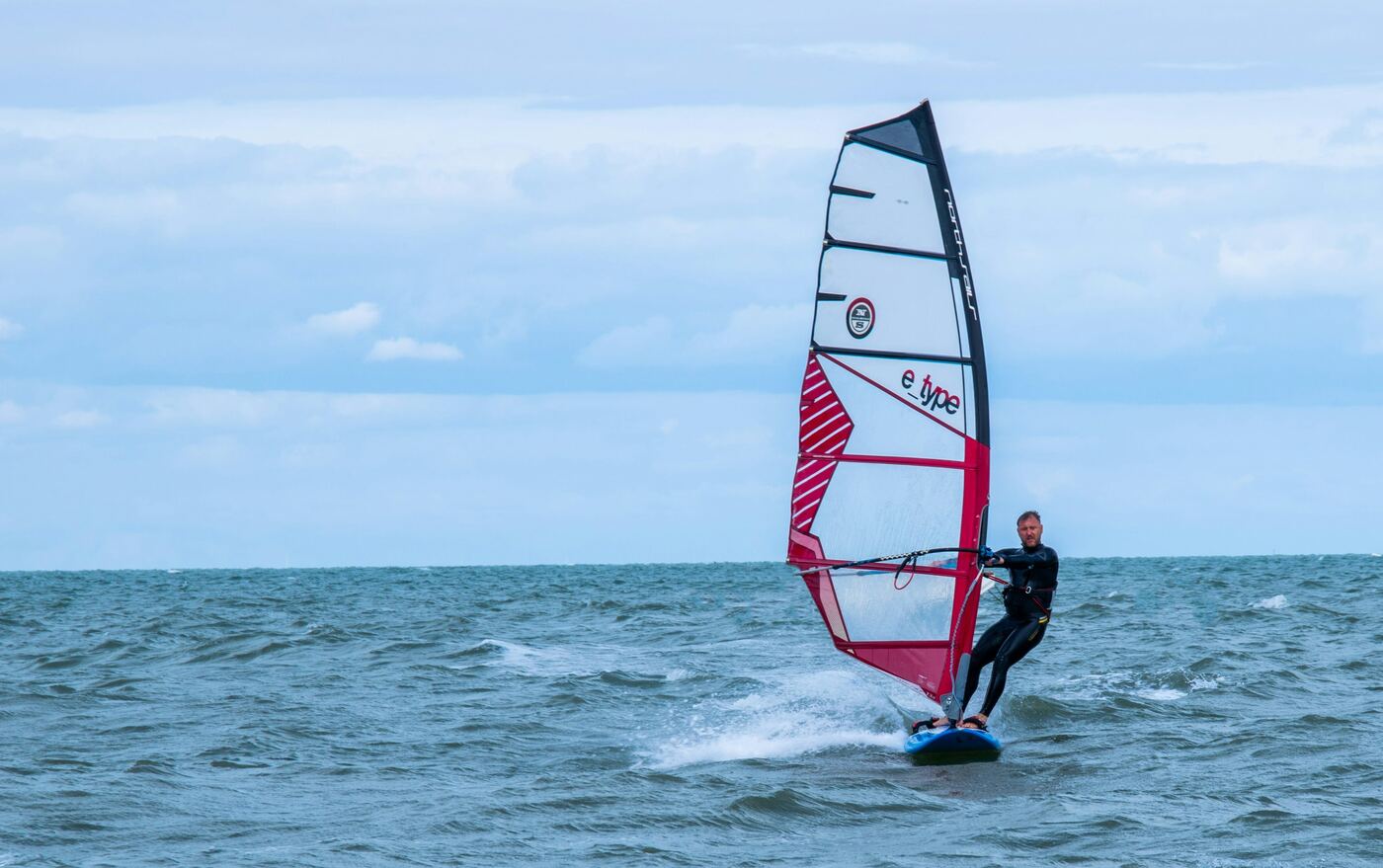 Windsurfer carving a turn on open water, the signature sight at Las Cucharas