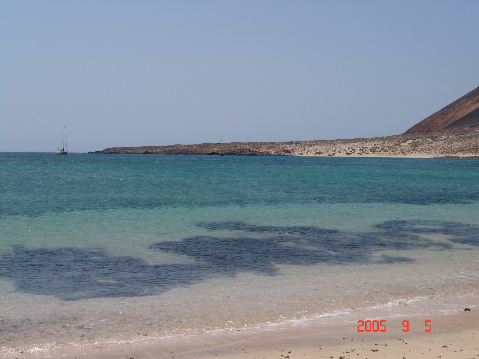 Pale-sand beaches of Playa Francesa and La Lajita on the south coast of La Graciosa, with Montaña Amarilla in the distance